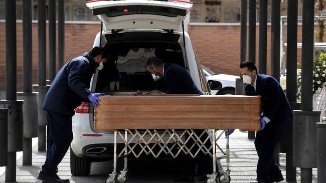 Petugas medis terlihat memasukan peti mati ke sebuah mobil ambulans di New York beberapa waktu lalu. Kematian akibat corona di AS capai 4.054 orang, lebih banyak dari Cina. (AFP/OSCAR DEL POZO/CNN)